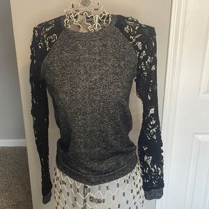 Small light sweater top with lace sleeves.